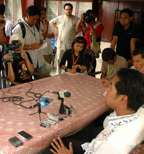 Khairy at a presss conference in Kg Badong, watched over by his aide, Dax (standing behind the photographer, hands on hips). Photos by Danny Lim.